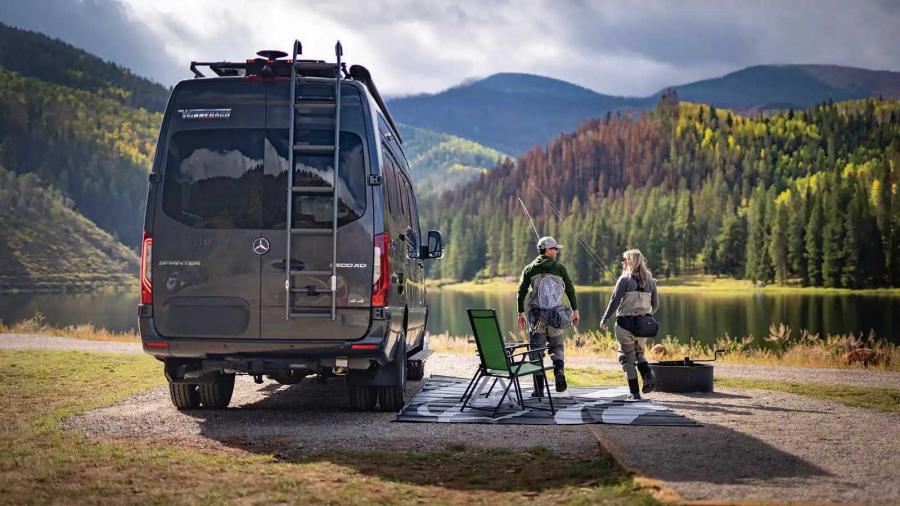 Couple fishing beside their campervan in Colorado. Fall foliage above the lake.
